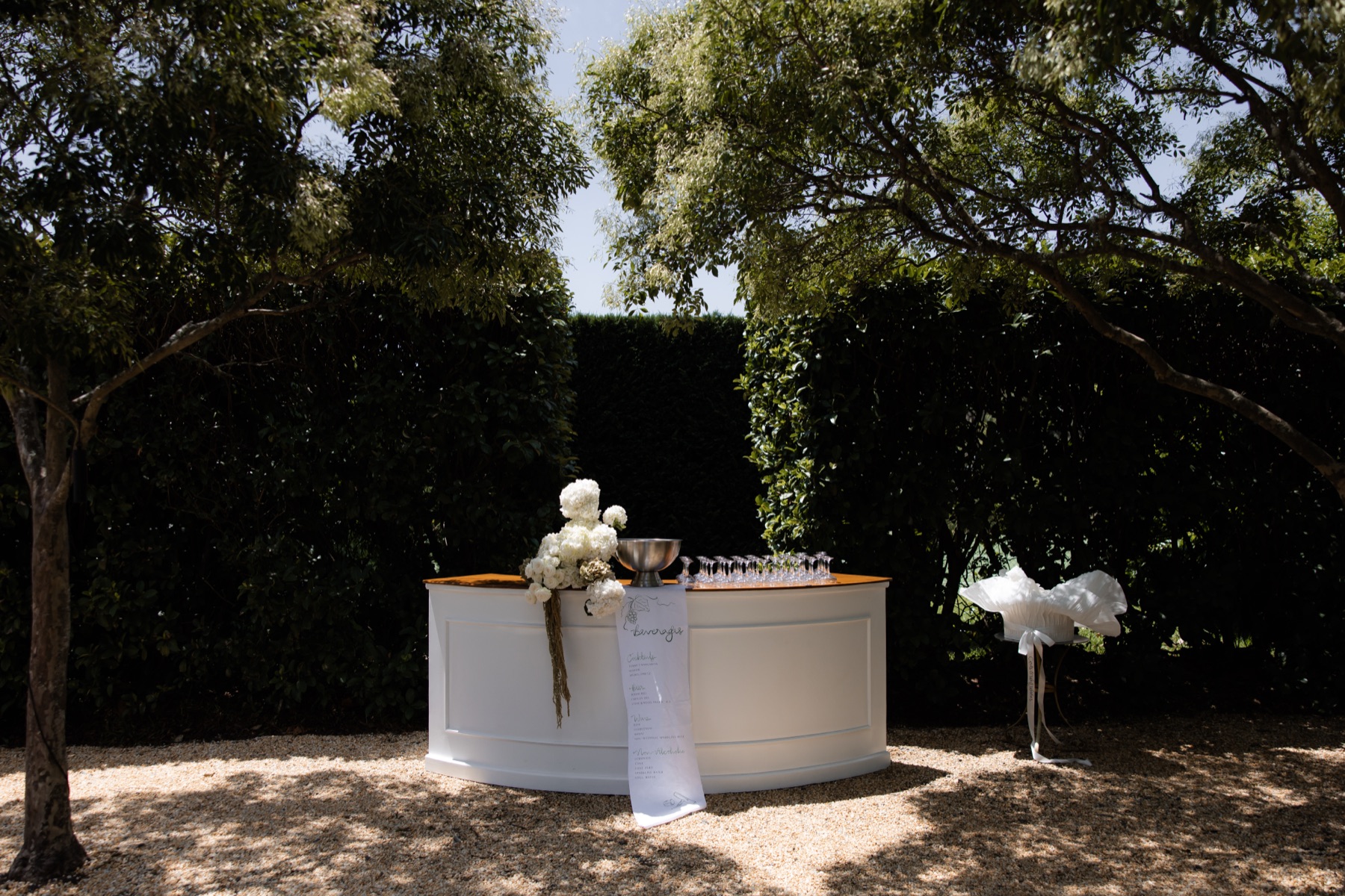 Elegant garden wedding bar station with champagne and white florals, catered by Michelone at Home in Sydney